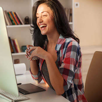 A laughing woman is reading an informative blog by Leduc website company, INM